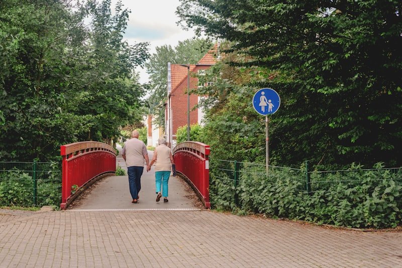 Elderly couple walking briskly across a bridge outdoors