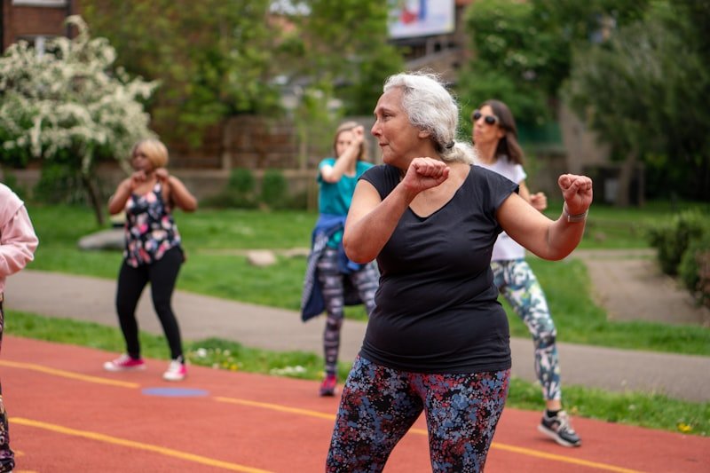 Older woman doing exercises at an outdoor fitness class
