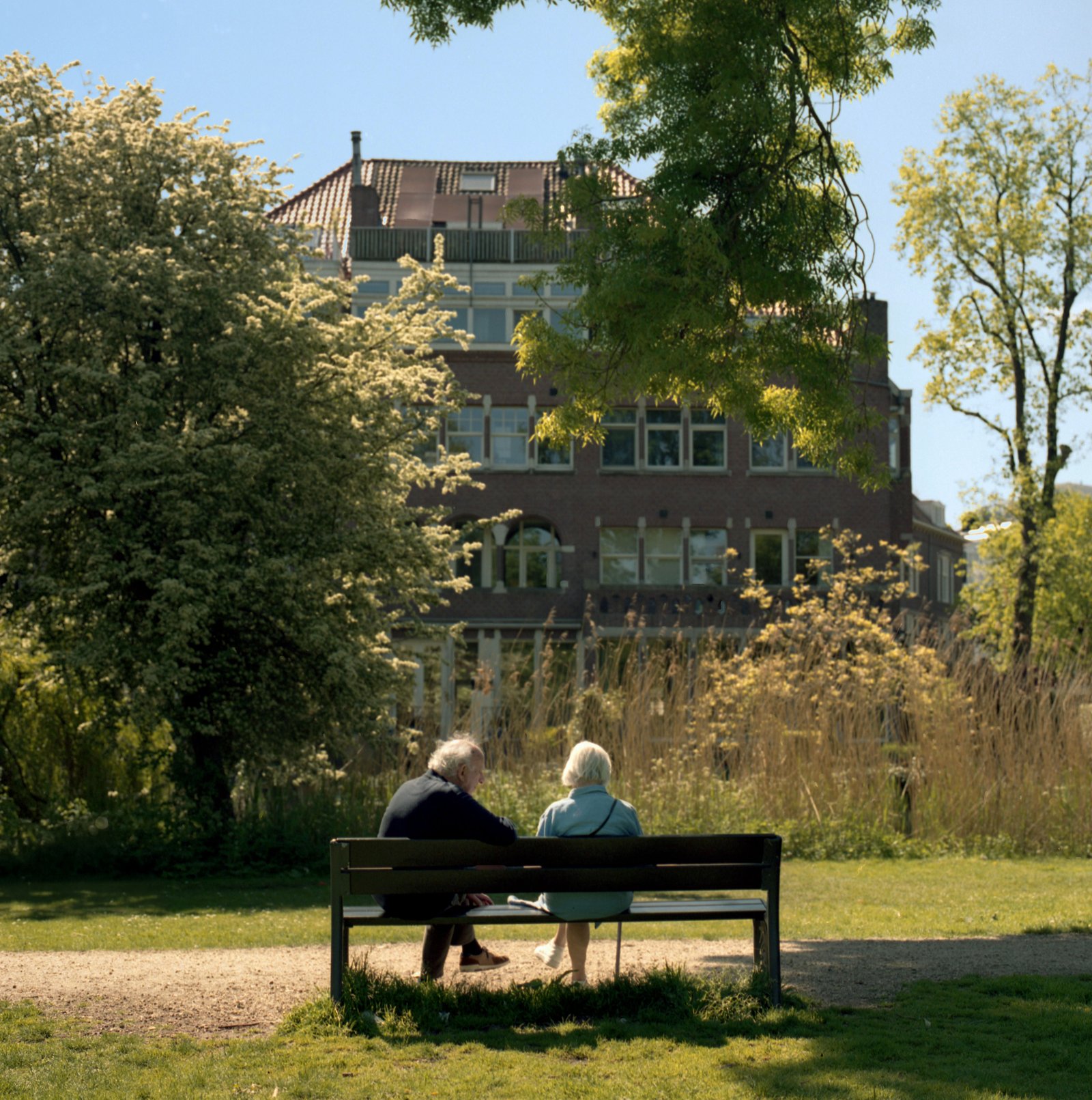 Elderly couple relaxing together on a park bench outdoors
