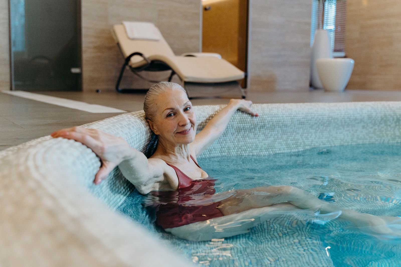 Older woman sitting comfortably in a pool during a water exercise session