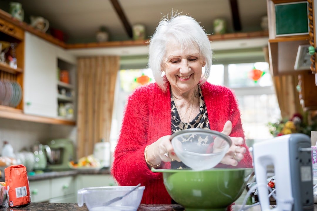 An older woman mixing ingredients in a bowl in her kitchen