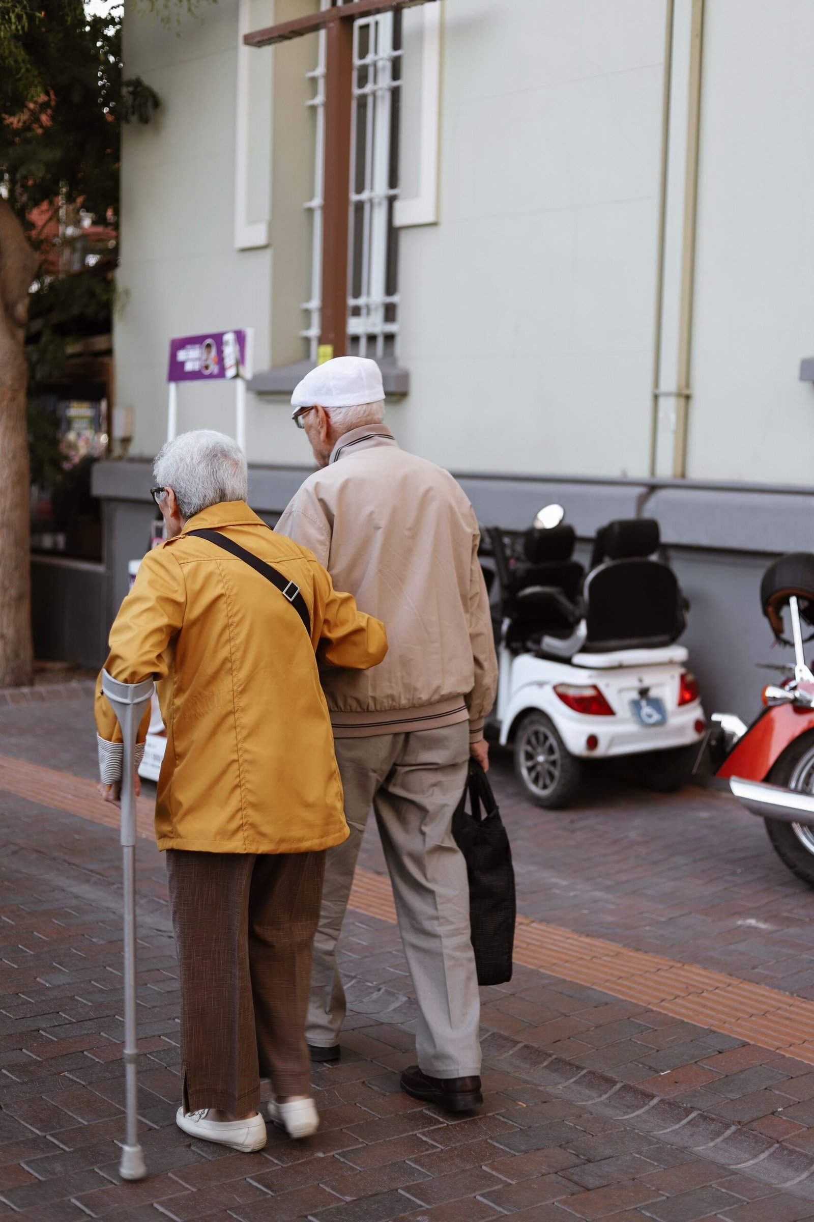 Senior couple walking hand in hand together in a sunny park