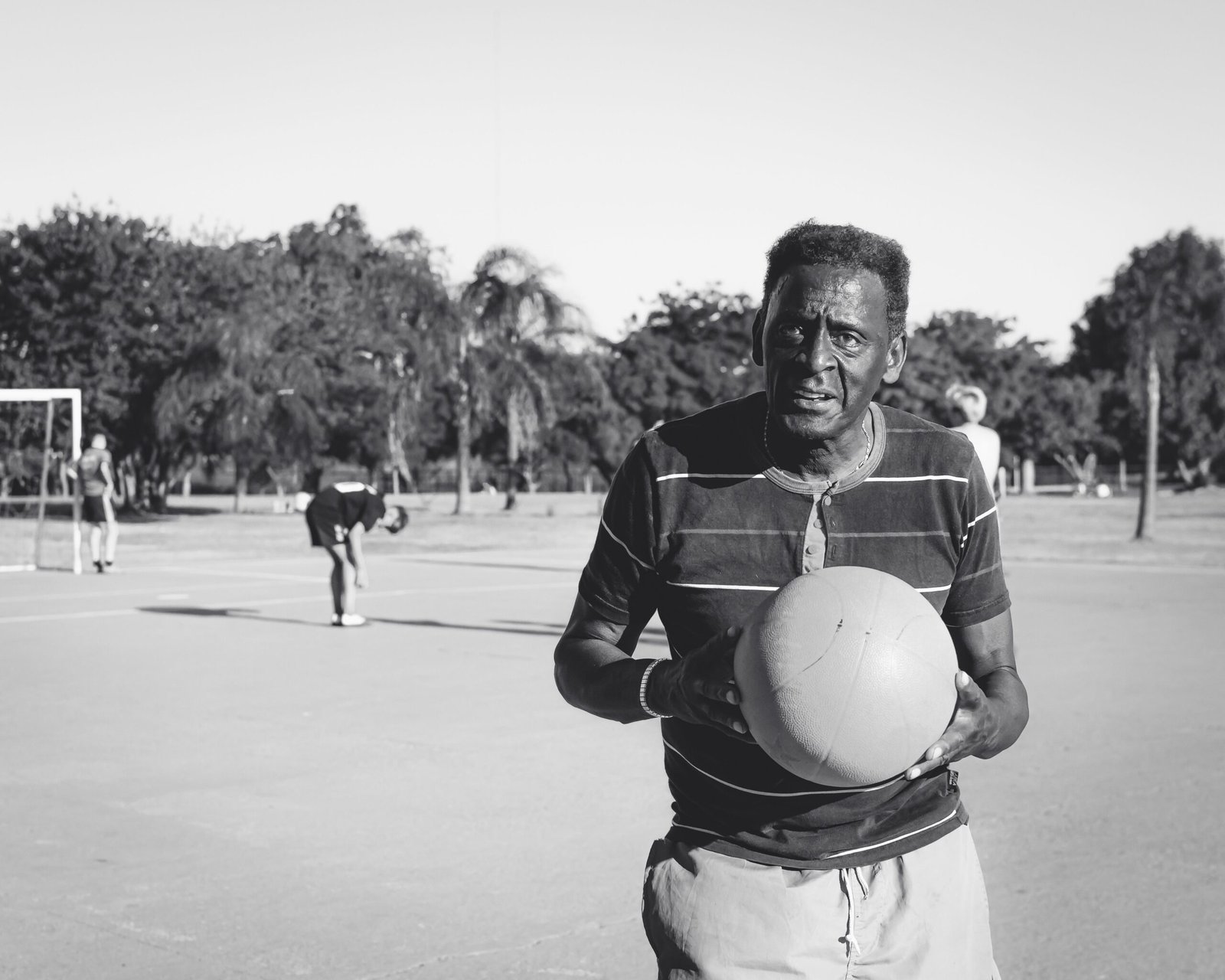 Senior man holding a basketball outdoors, staying active