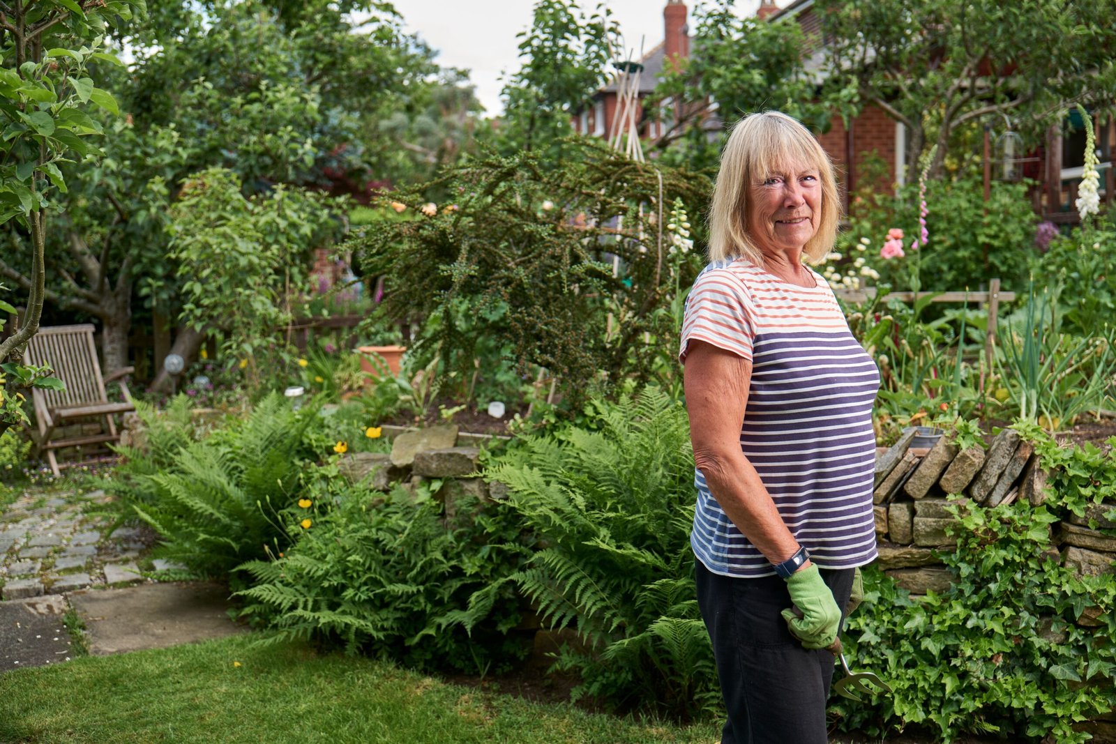 Smiling senior woman working in a green garden