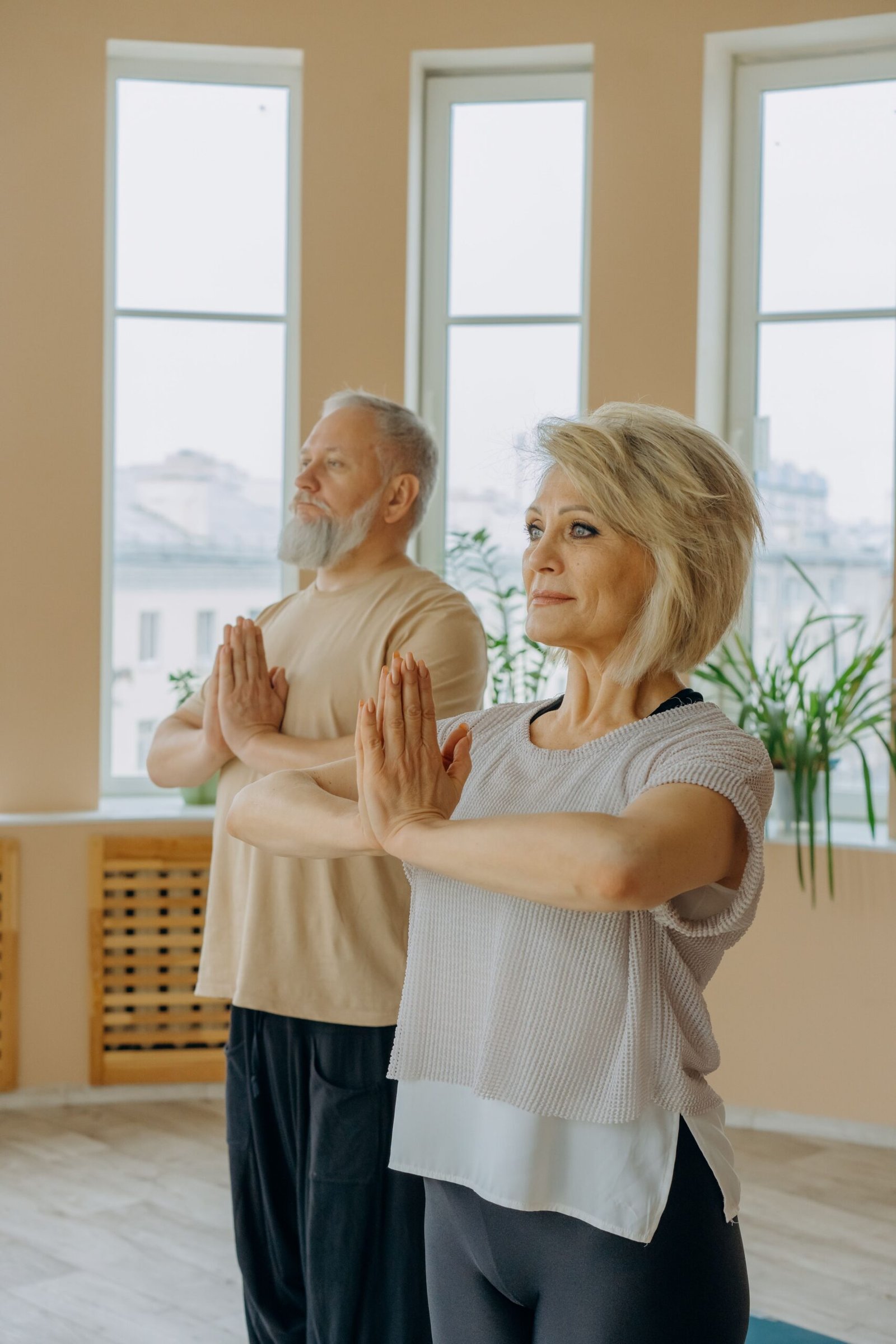 Senior couple relaxing and meditating together indoors to manage stress