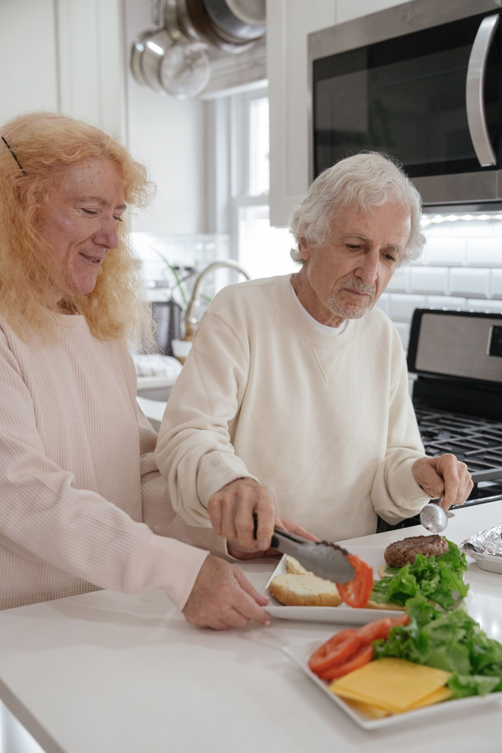 Elderly couple preparing food together in a modern kitchen