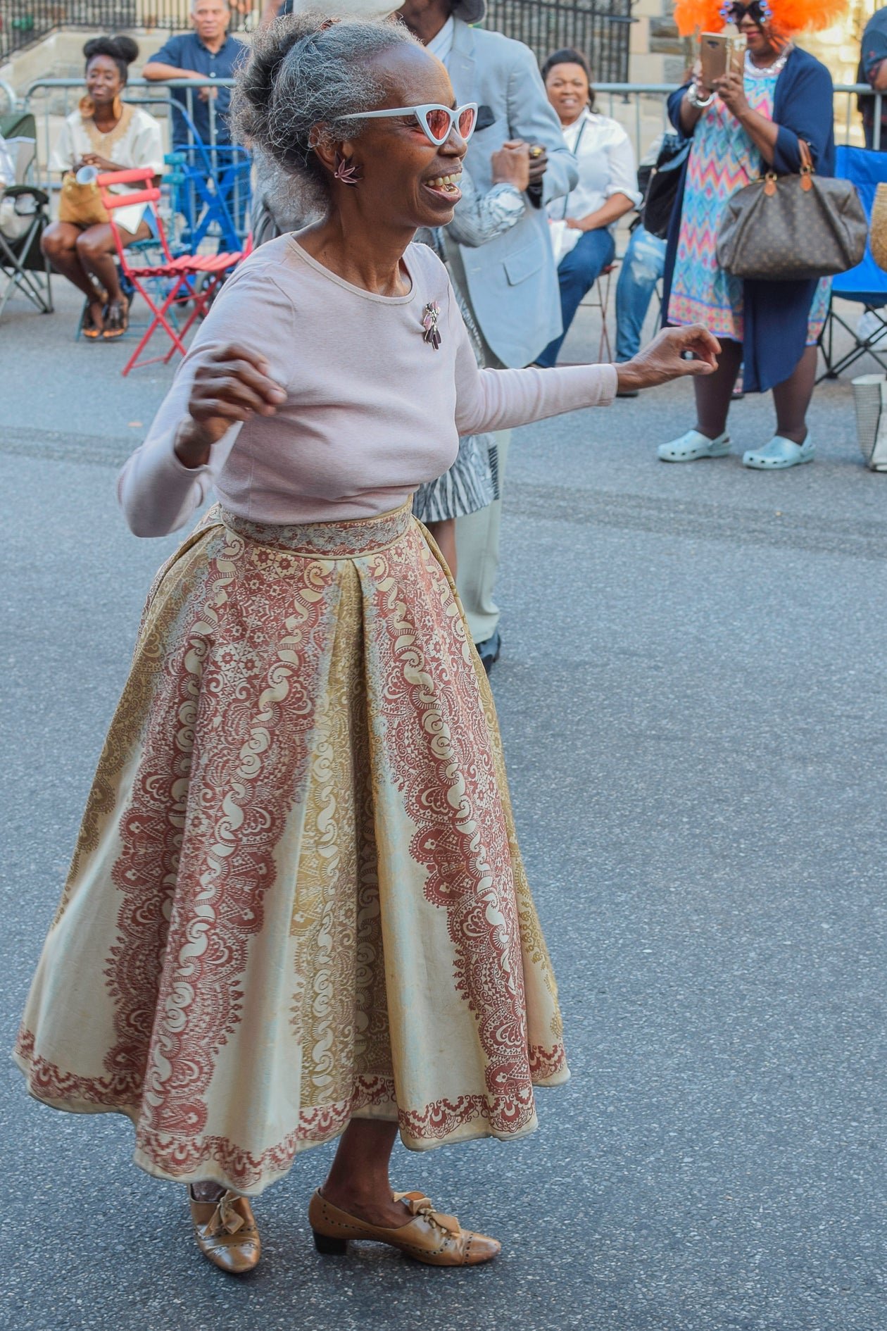 An older woman dancing joyfully outdoors