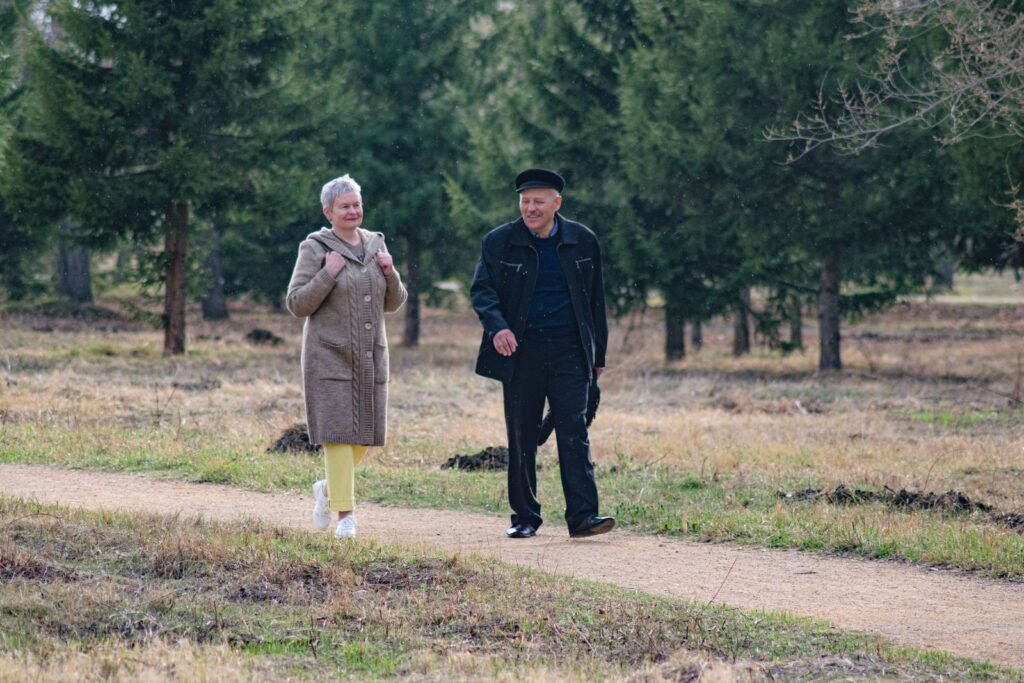 Older couple walking side by side on a park path on a spring day