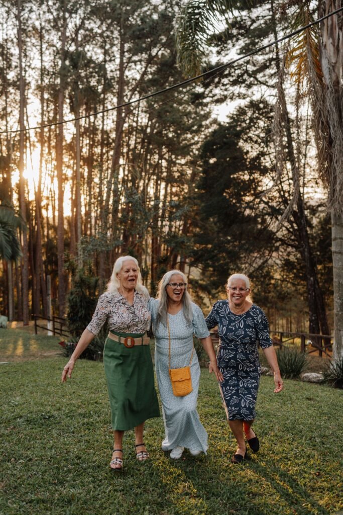 Three Latina women in their sixties laughing as they walk together outdoors in Brazil