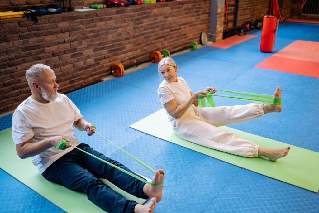 Older couple doing a resistance band workout together on exercise mats