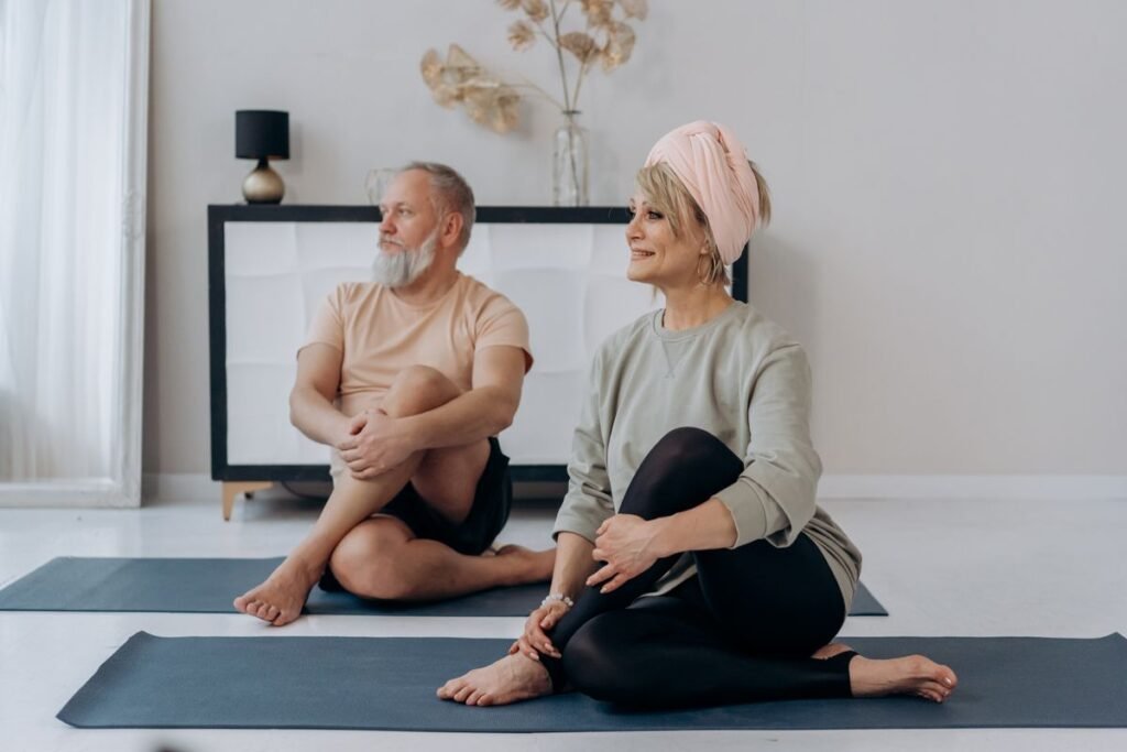Elderly couple doing a gentle yoga and stretching session together at home
