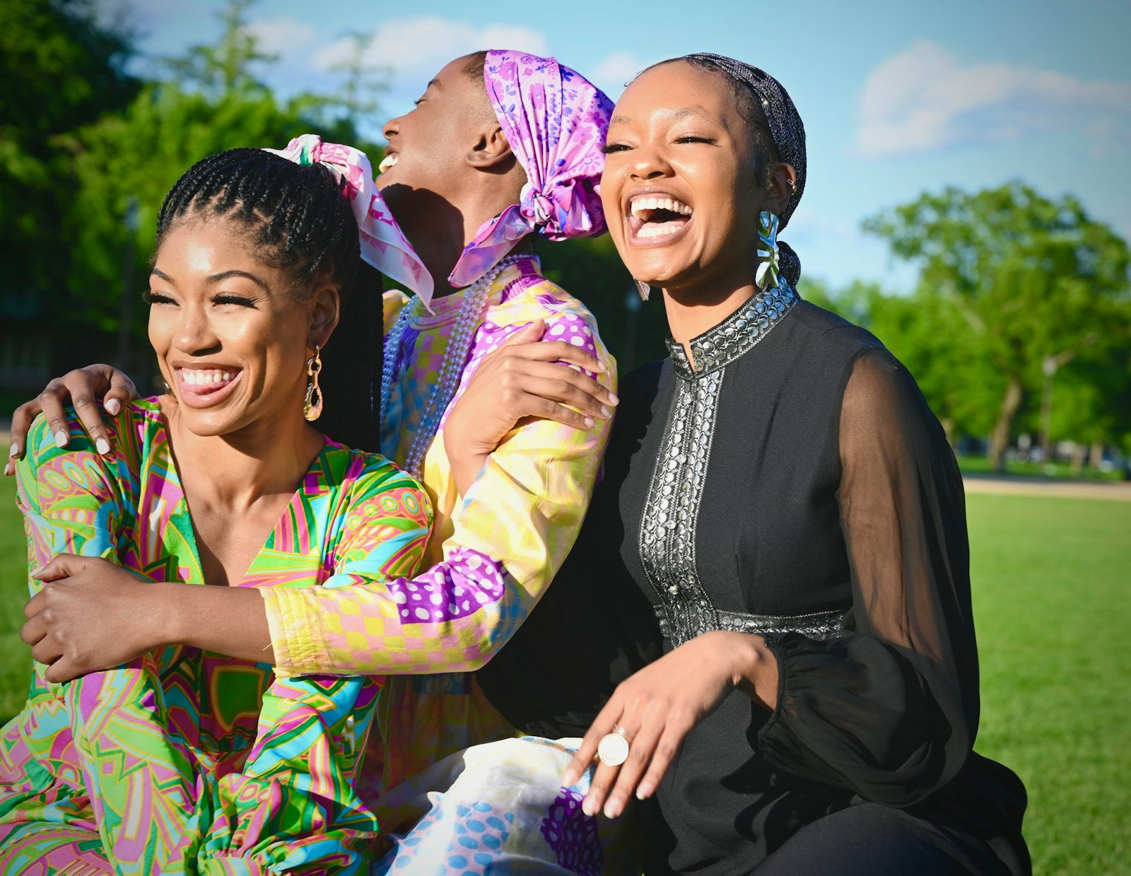 Three friends laughing together outdoors on the National Mall in Washington DC