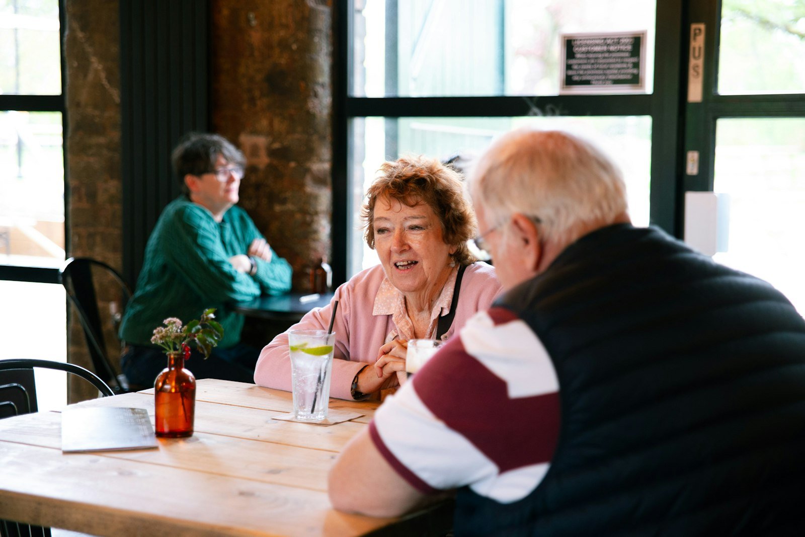 Two older couples talking over coffee at a table in a cafe