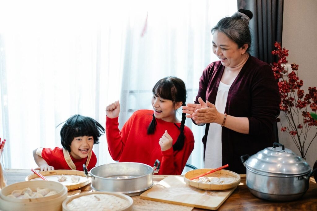 Asian grandmother cooking a home-made meal in the kitchen with her grandchildren