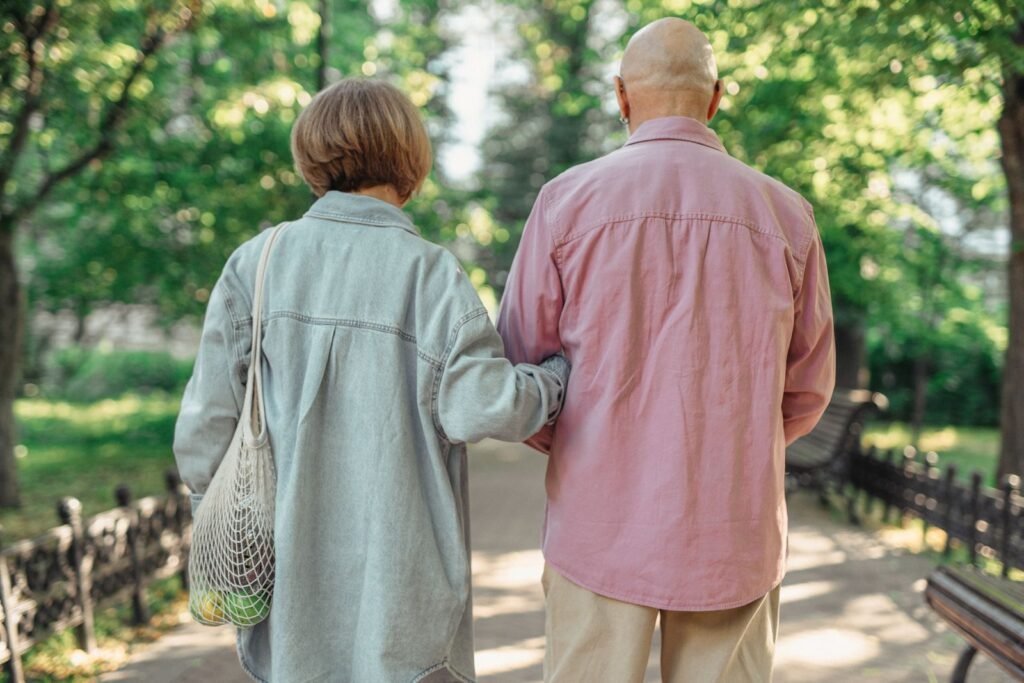 Senior couple walking together through a sunlit park