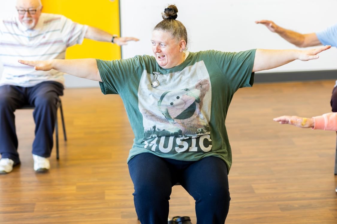 Seniors participating together in a seated group exercise class