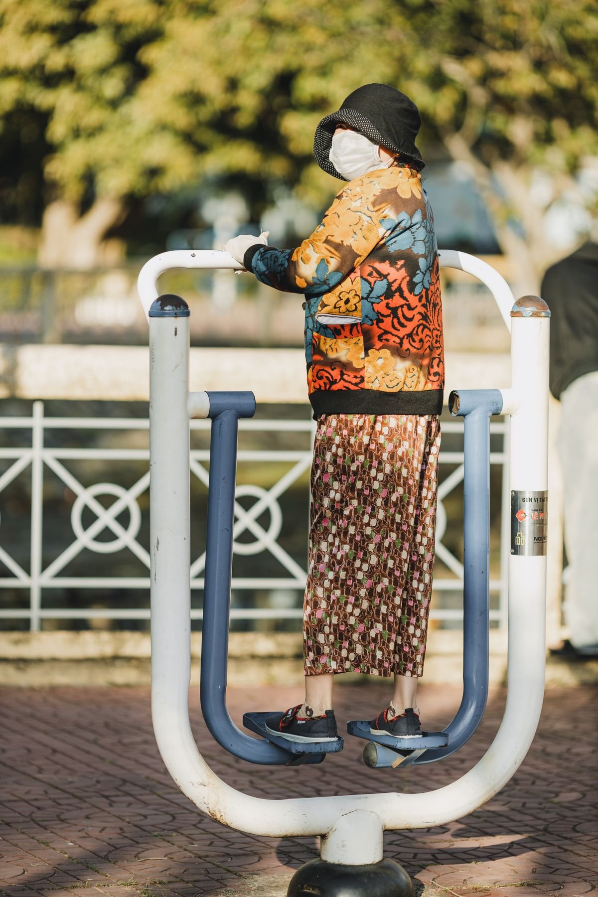 Older woman using outdoor exercise equipment in a park