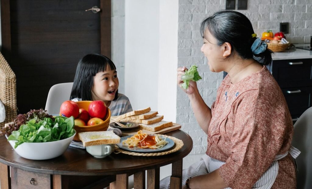 Older woman and her granddaughter sharing a healthy salad in a kitchen