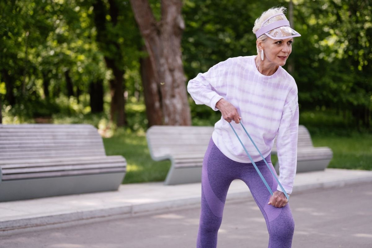 Senior woman exercising with a resistance band in a park