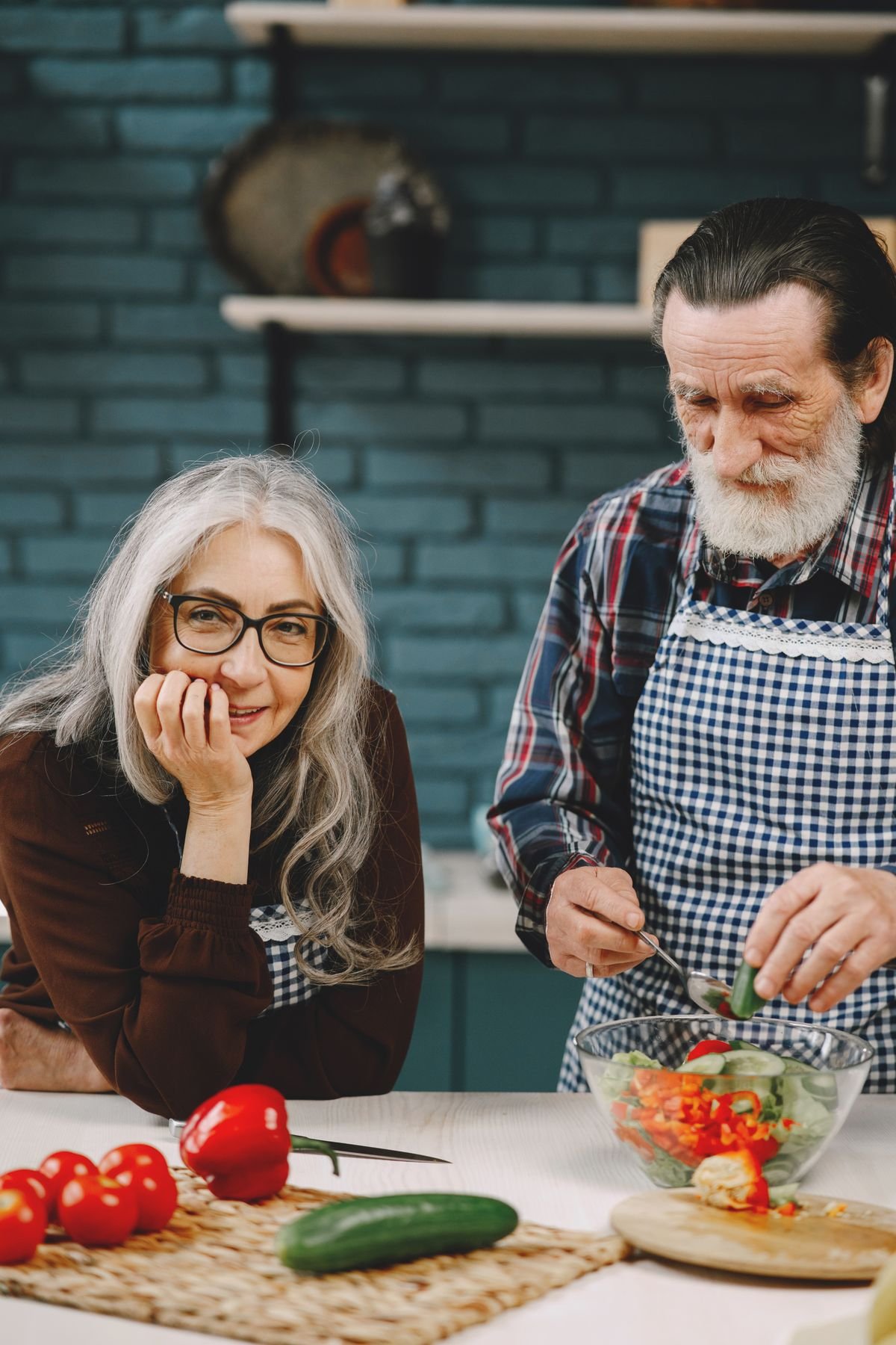 Older couple preparing a salad together in their kitchen