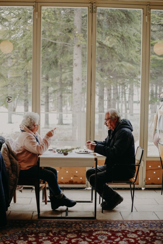 Older couple sharing a meal together at a table by a sunny window
