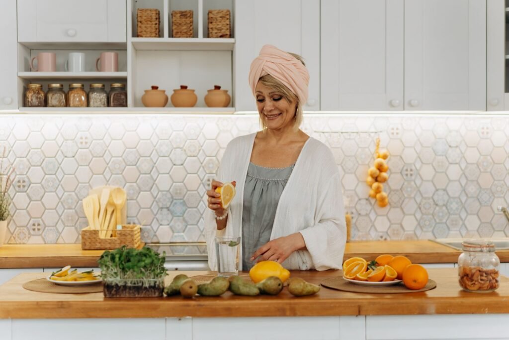 Mature woman in a head wrap preparing fresh fruit in a bright kitchen