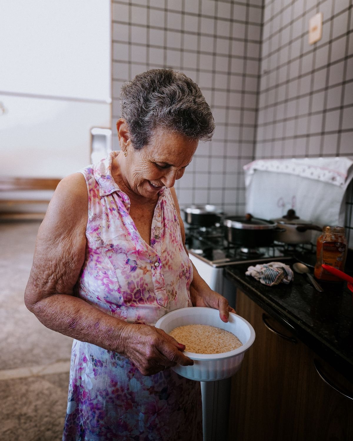 Older woman preparing food at the stove in her kitchen