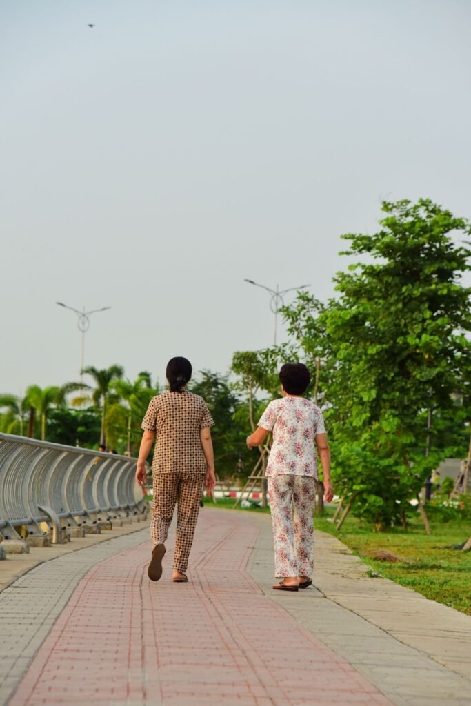 Two older women walking together along a park path